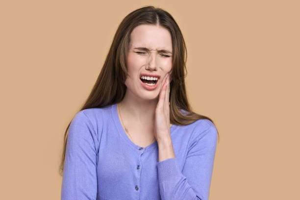 Young woman with severe toothache seeking emergency dentist