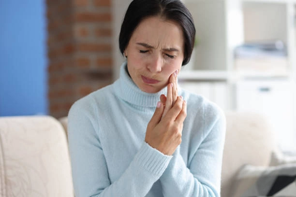 Woman experiencing toothache, urgent visit to emergency dentist